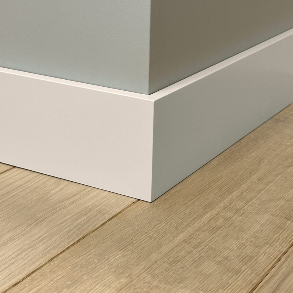 Modern witte plint op houten vloer